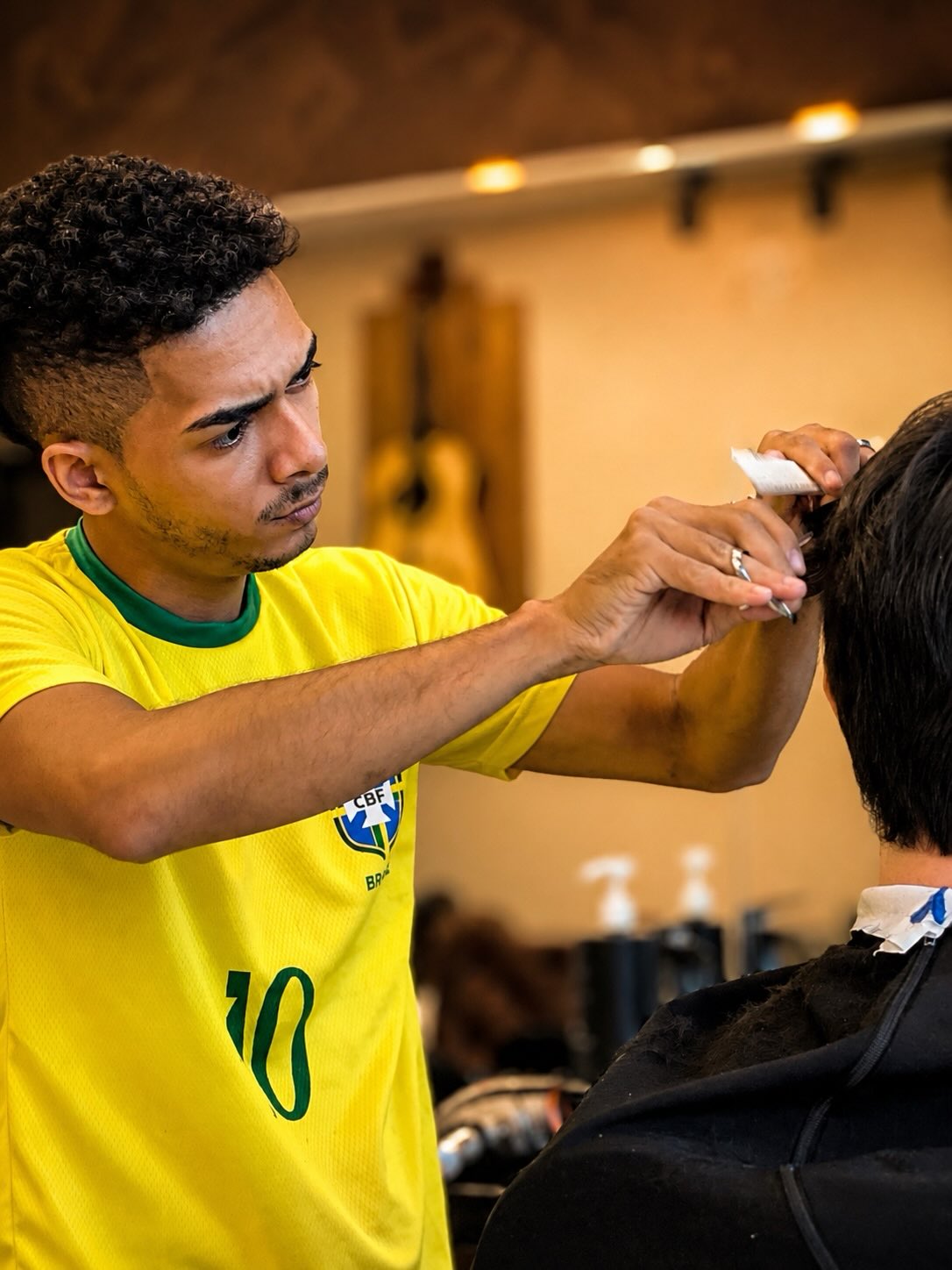 Barbeiro finalizando corte com tesoura